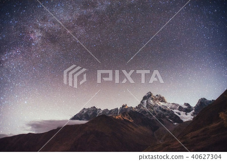 Fantastic starry sky. Autumn landscape and snow-capped peaks 40627304