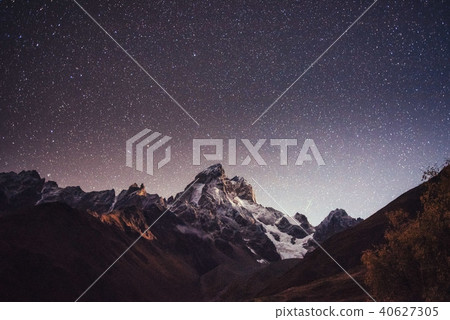 Fantastic starry sky. Autumn landscape and snow-capped peaks 40627305