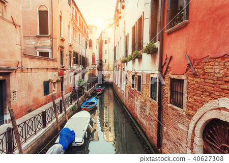 Green water canal with gondolas and colorful facades 40627308