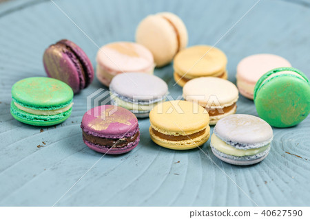 Close-up colorful French or Italian macaron on blue wooden table. Macarons is French dessert served 40627590