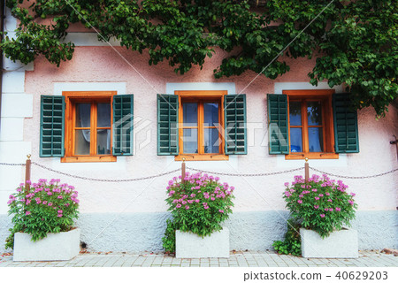 Typical Austrian Alpine house with bright flowers on the balcony 40629203
