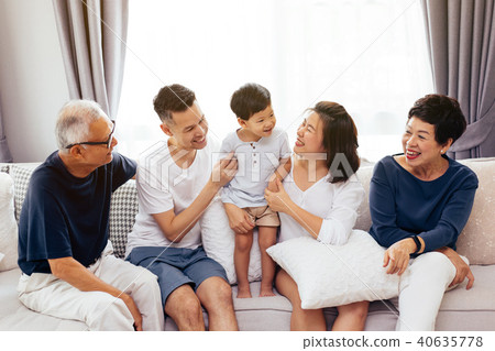 Happy Asian extended family sitting on sofa 40635778