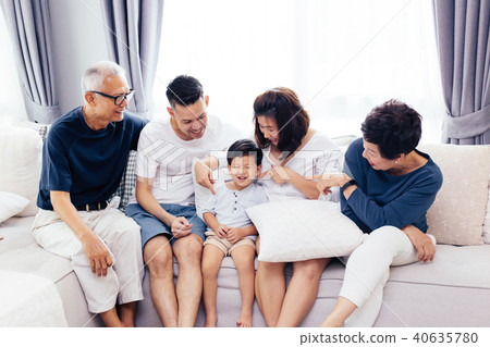 Happy Asian extended family sitting on sofa 40635780
