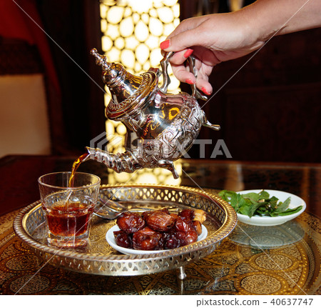 Black tea in the tea pot with mint and dates plate 40637747