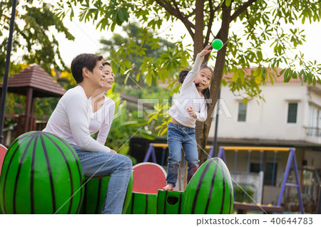 Young family with little girl having fun in park.  40644783