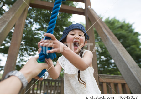 Parent and child handing rope in park 40645018