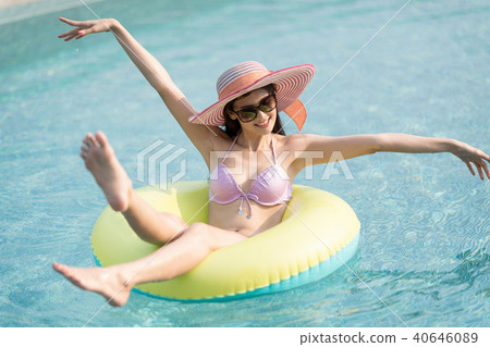 Woman in bikini on green air inflatable ring. 40646089