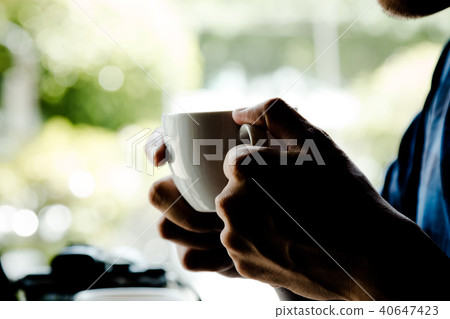 Close up of man holding hot latte coffee cup Close up of man holding hot latte coffee cup 40647423