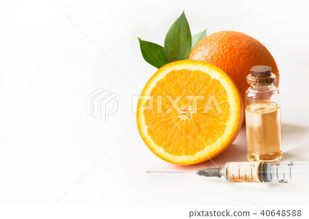 Orange fruit and plastic disposable syringe. 40648588