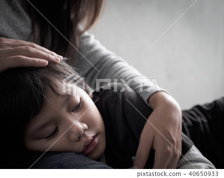 Closeup sad little boy being hugged by his mother Closeup sad little boy being hugged by his mother 40650933