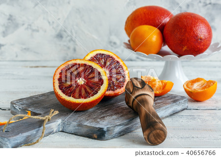 Blood orange cut in half and wooden citrus press. Blood orange cut in half and wooden citrus press. 40656766