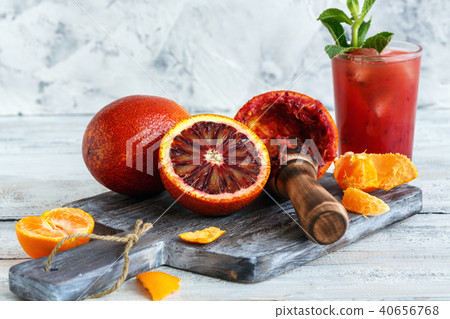 Blood oranges, citrus press and a glass of juice. Blood oranges, citrus press and a glass of juice. 40656768