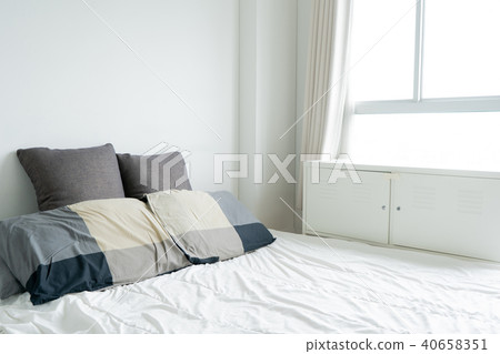 sunlight Bed maid-up with clean white pillows sunlight Bed maid-up with clean white pillows 40658351