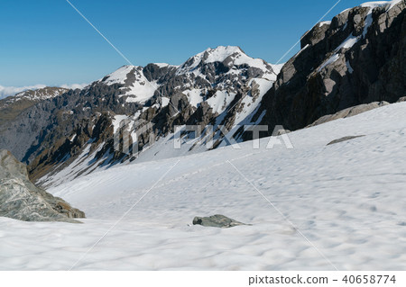 Snow covered over black rock volcano mountain 40658774