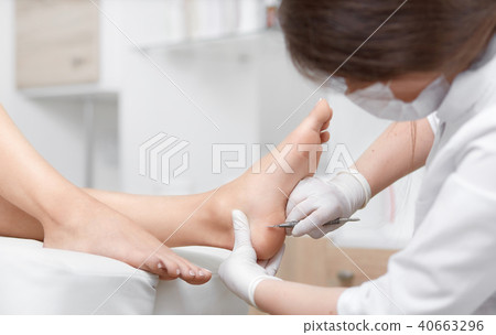 Profeesional doctor polish callus and corn on feet of client. Profeesional doctor polish callus and corn on feet of client. 40663296