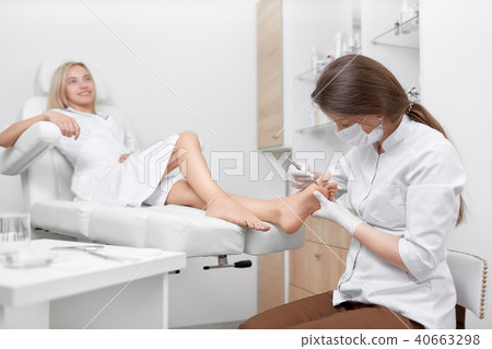 Podiatrist doctor cleaning foot from callus. Podiatrist doctor cleaning foot from callus. 40663298