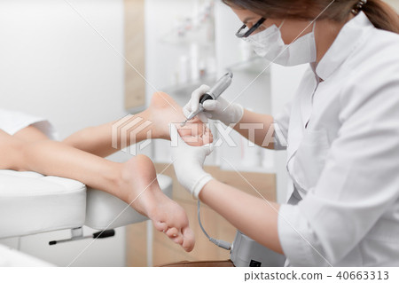 Podiatrist using special grinding equipment. 40663313