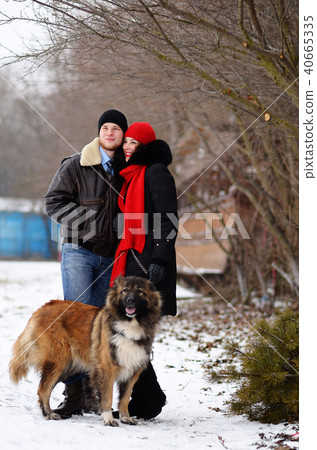 Happy couple with dogs in winter forest.  40665335
