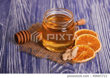 Honey in glass jar, ginger and dry slices of orange on vintage wooden background. Aromatic spices. 40665722