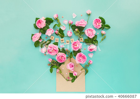 Creative layout with pink tea rose flowers, leaves fly out of croped craft paper envelope in shape Creative layout with pink tea rose flowers, leaves fly out of croped craft paper envelope in shape 40666087
