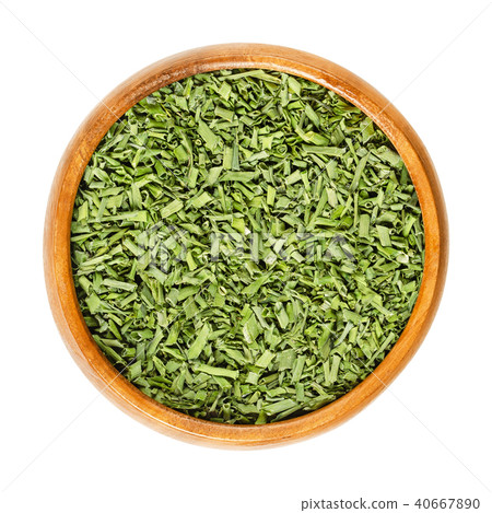 Dried chives in wooden bowl over white 40667890