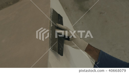 worker applying putty on the wall near corner worker applying putty on the wall near corner 40668079