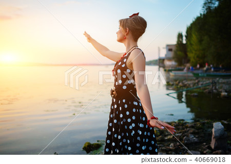 A beautiful young woman dressed standing  40669018