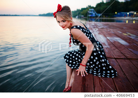 A beautiful young woman dressed sitting on the  40669453