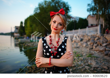 A beautiful young woman dressed standing by the  40669620