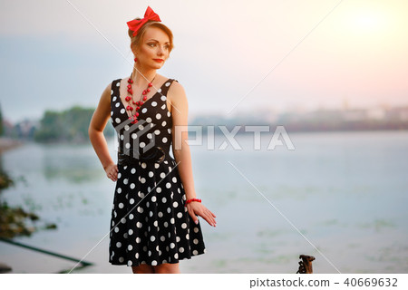 A beautiful young woman dressed standing by  40669632