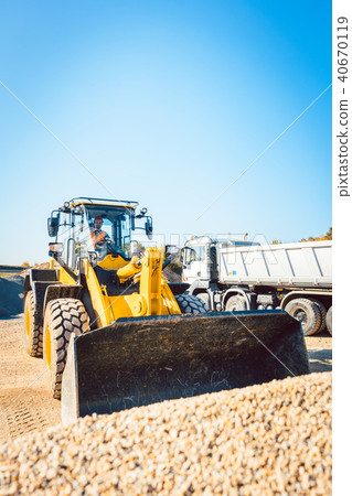 Construction workers doing earthworks with wheel loader 40670119