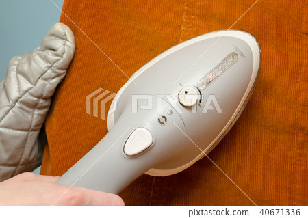 Female hand with steam iron, close-up 40671336