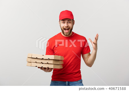 Delivery Concept: Handsome pizza delivery man courier in red uniform with cap holding pizza boxes 40671588