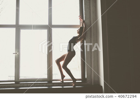 beautiful girl dancer with long flowing hair in black clothes, swimsuit,in a beautiful beautiful 40672294