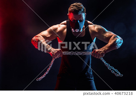 Portrait of muscular sportsman tearing metal chain. Black background Portrait of muscular sportsman tearing metal chain. Black background 40673218