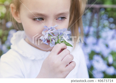 Girl child sniffing flowers, close-up Girl child sniffing flowers, close-up 40673714