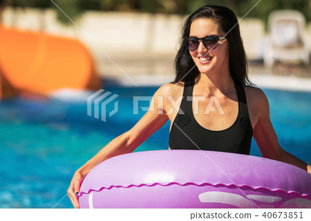 lady holding rubber ring near the swimming pool lady holding rubber ring near the swimming pool 40673851