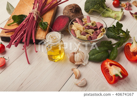 Colorful pasta and cooking ingredients on white wood Colorful pasta and cooking ingredients on white wood 40674167