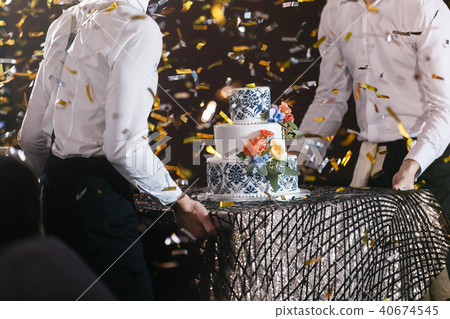 waiter will present at the restaurant. Wedding cake with flowers. Bride and groom cut sweet cake on 40674545