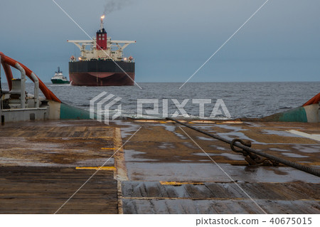 AHTS vessel doing static tow tanker lifting. Ocean tug job 40675015
