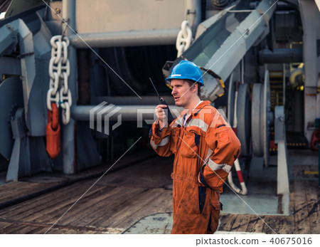 Marine Deck Officer or Chief mate on deck of ship with VHF radio 40675016