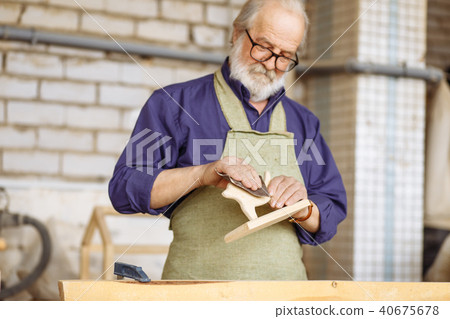 pensioner using glasspaper while working in the garage 40675678