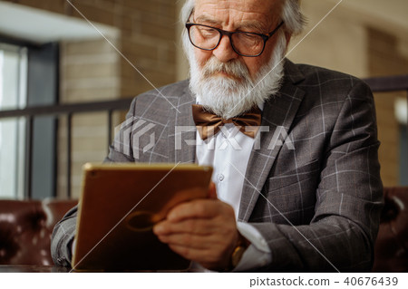 senior citizen with white hair and beard is all clued up about gadgets senior citizen with white hair and beard is all clued up about gadgets 40676439