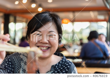 Asian woman in barbeque yakiniku grill restaurant Asian woman in barbeque yakiniku grill restaurant 40676819