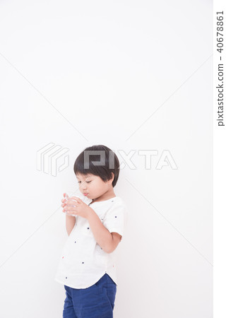 A boy drinking water with a cup A boy drinking water with a cup 40678861