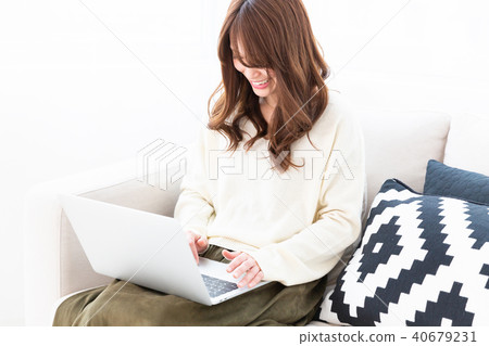 A woman watching a laptop computer in a room 40679231