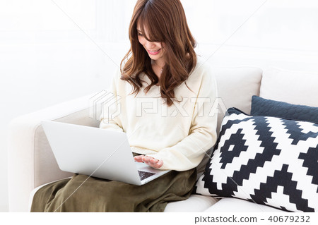 A woman watching a laptop computer in a room 40679232