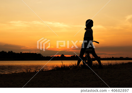 Cute little boy play and riding bicycle sunset  40682897