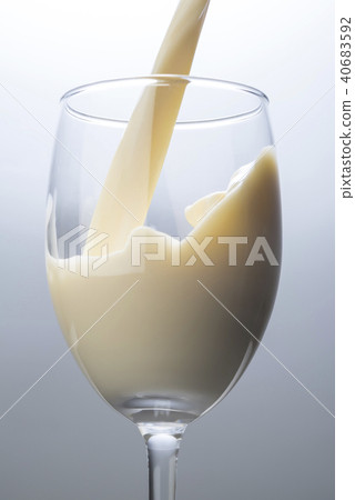Pour soy milk into a glass 40683592