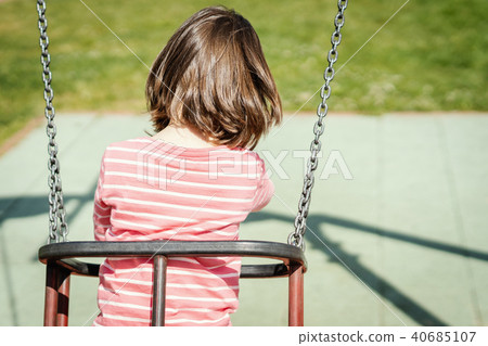 little girl is swinging on a swing at the playground little girl is swinging on a swing at the playground 40685107